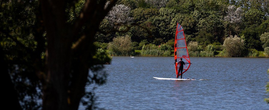 Ein Surfer auf einem ruhigen See