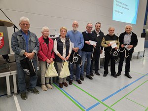 Zu sehen sind acht Personen, zwei Frauen und sechs Männer. Sie haben Urkunden erhalten.