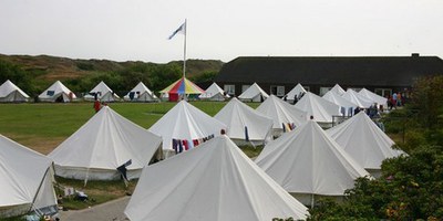 Man sieht einige Rundzelte und im Hintergrund ein festes Haus im Zeltlager Langoog